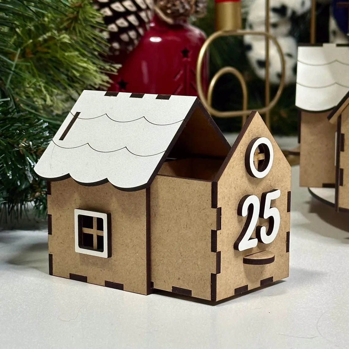 Cardboard house-shaped Advent calendar with '25' on a festive background