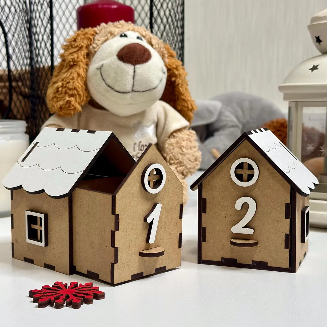 Two cardboard house-shaped number cards with a plush toy in the background