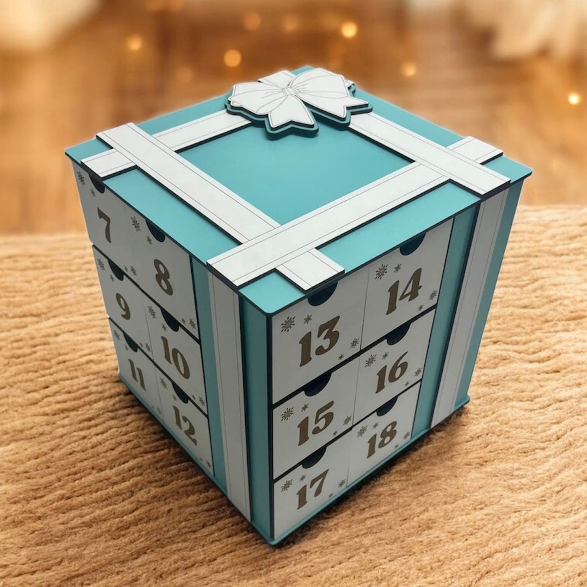 Teal and white advent calendar on a wooden surface with a blurred background