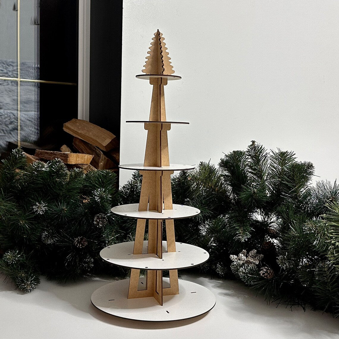 Wooden Christmas tree stand with white circular base against a snowy background