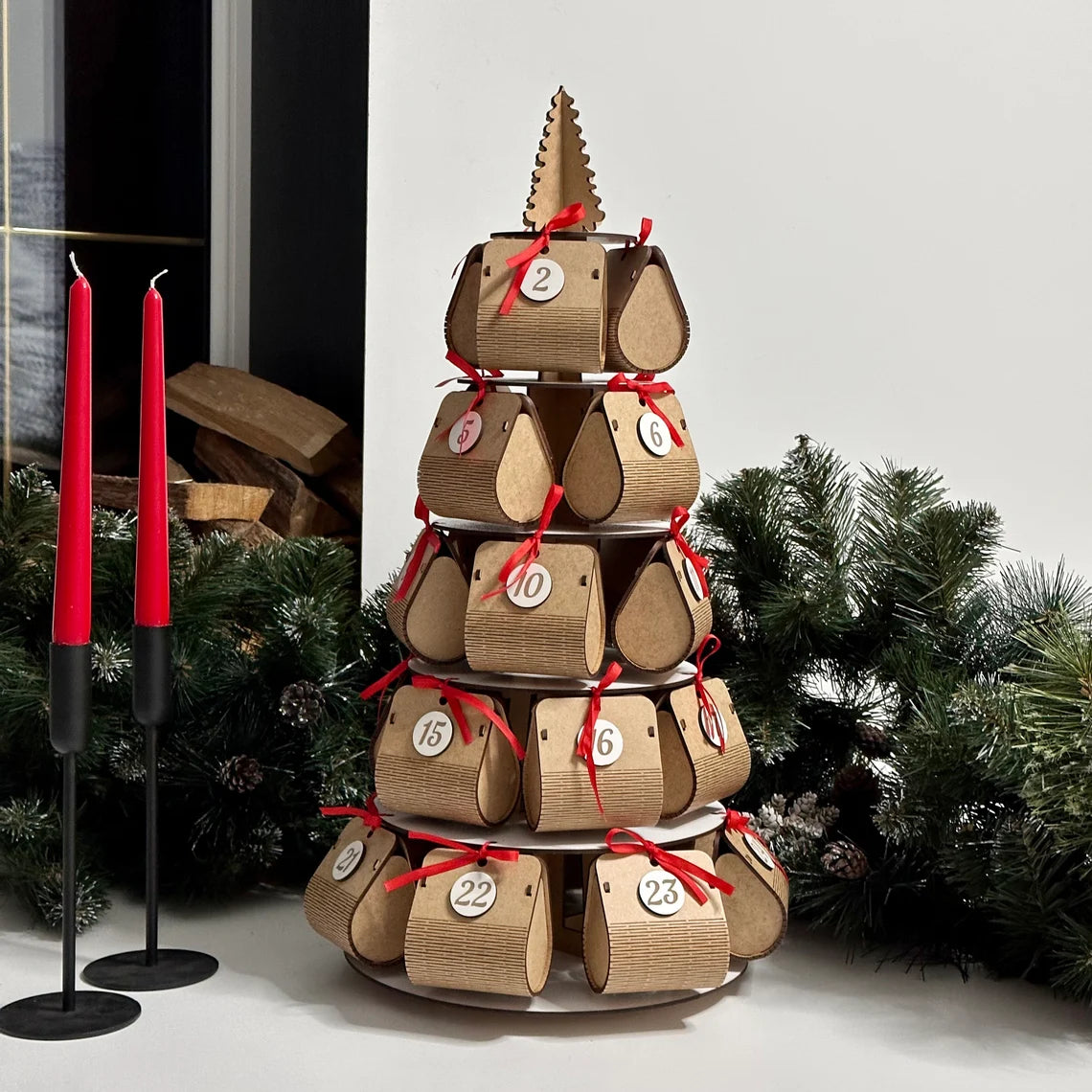 Wooden advent calendar stacked in a tower with Christmas decorations in the background.