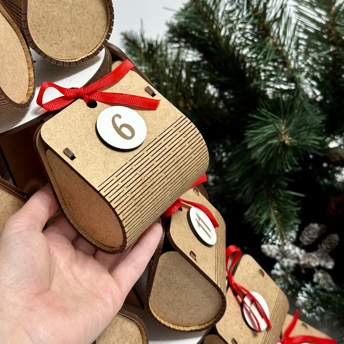 Advent calendar for Christmas holidays in the shape of a Christmas tree, made of wood