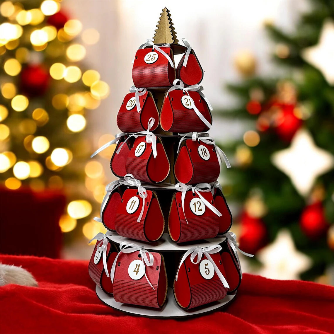 Red advent calendar with numbered boxes on a white stand against a festive background with Christmas trees.