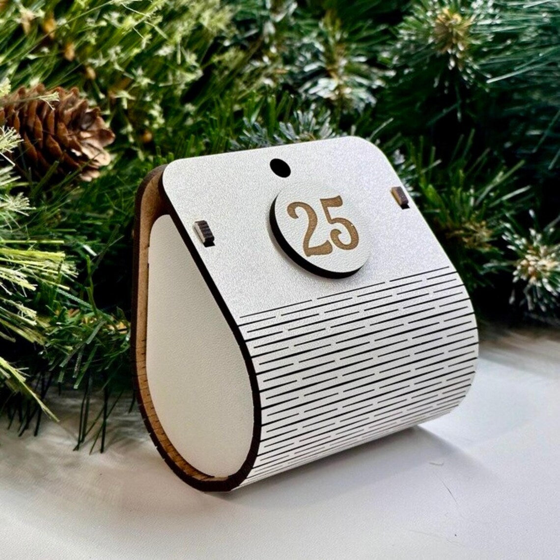Wooden advent calendar with number 25 against a Christmas tree background