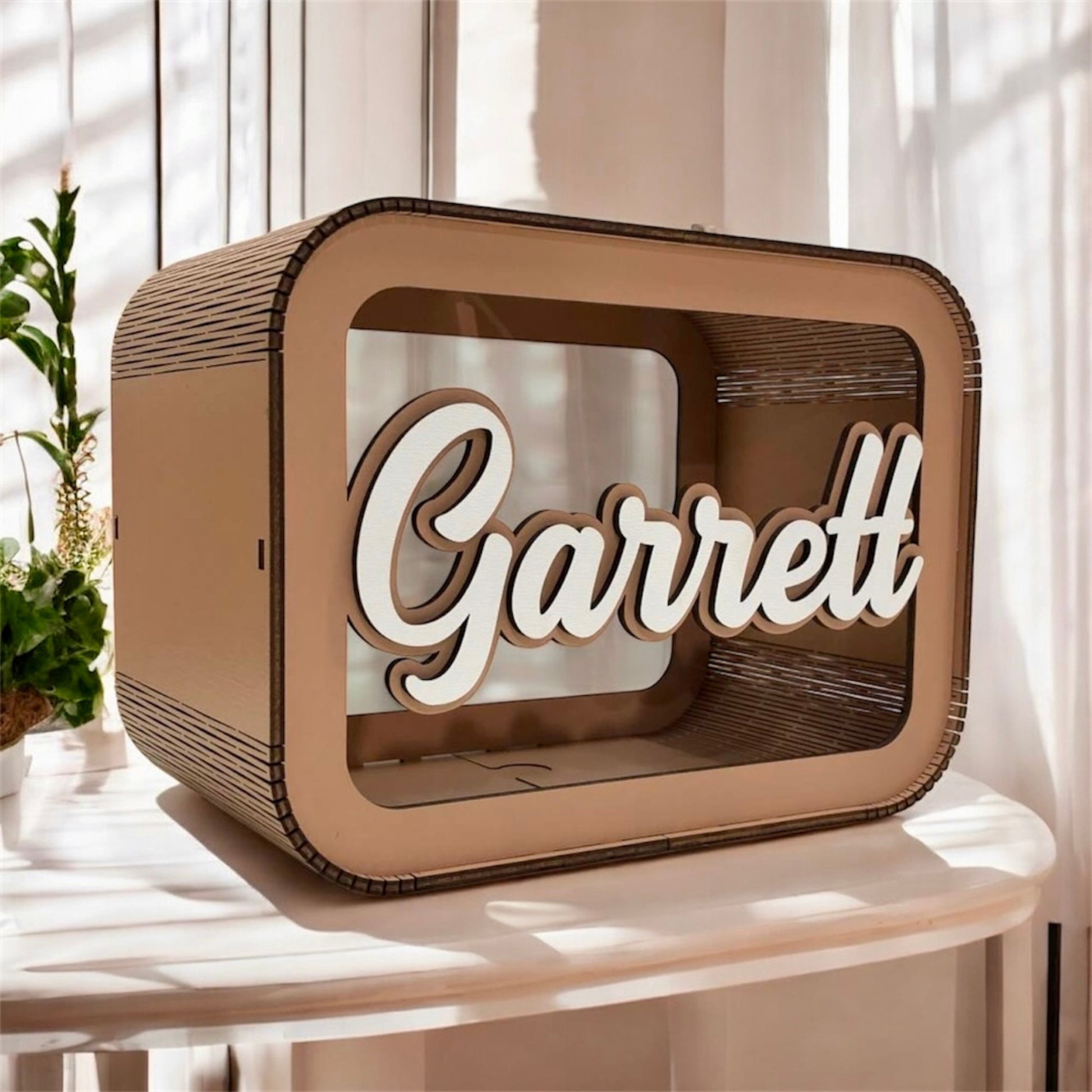 Wooden box with 'Garrett' engraved on it, placed on a surface with a blurred background.