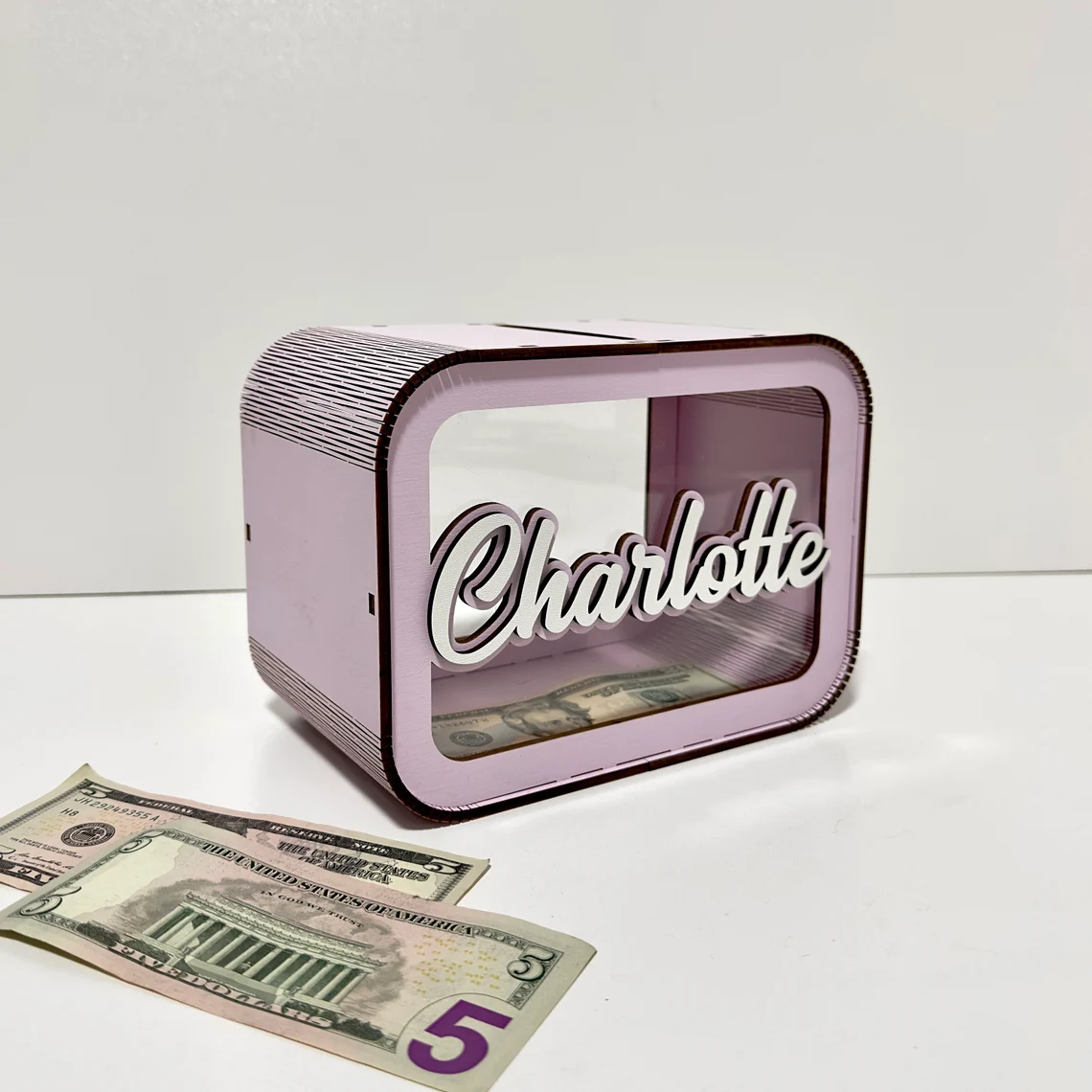 Pink money box with 'Charlotte' on a white background
