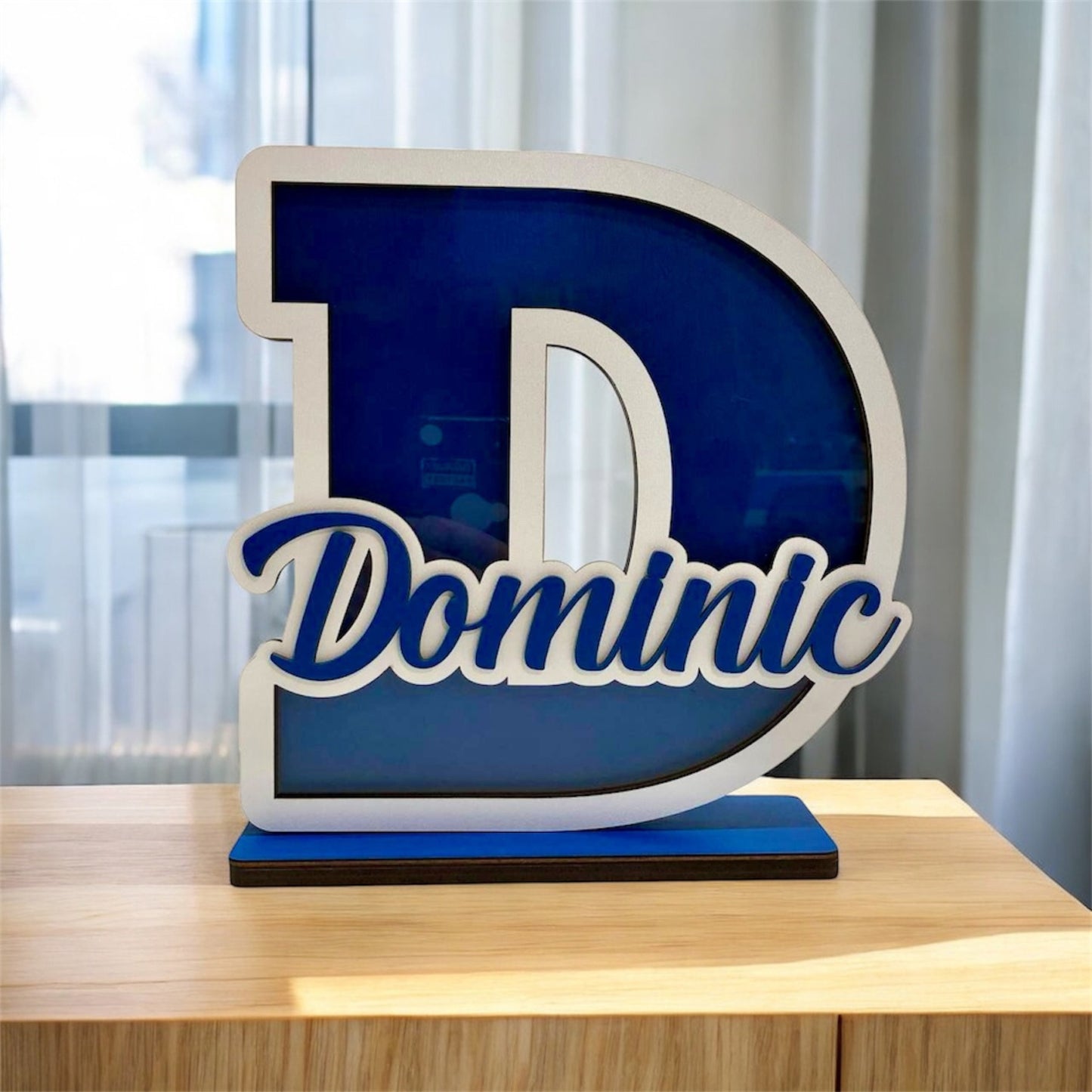 Decorative letter 'D' with the name 'Dominic' on a wooden surface.