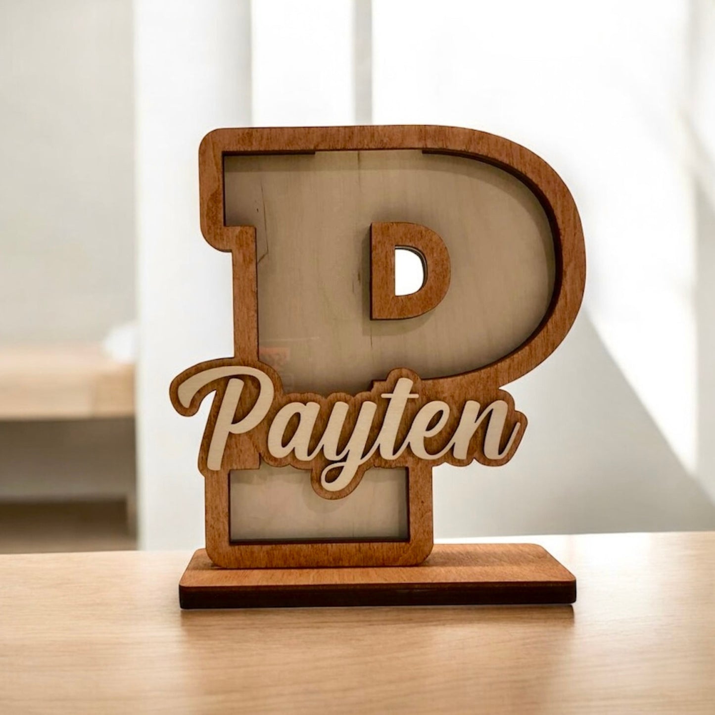 Wooden letter 'P' with 'Payten' engraved on a light background