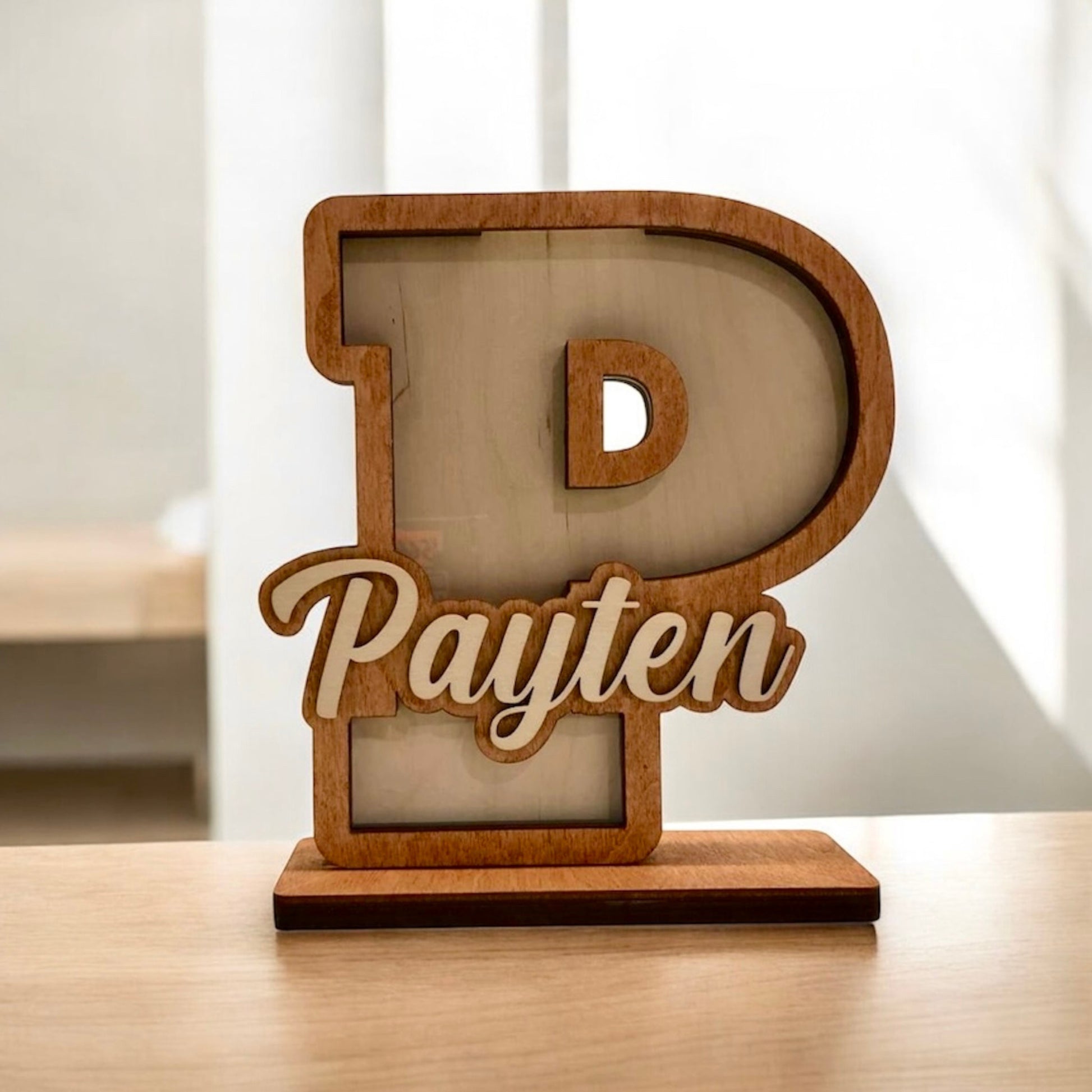Wooden letter 'P' with 'Payten' engraved on a light background
