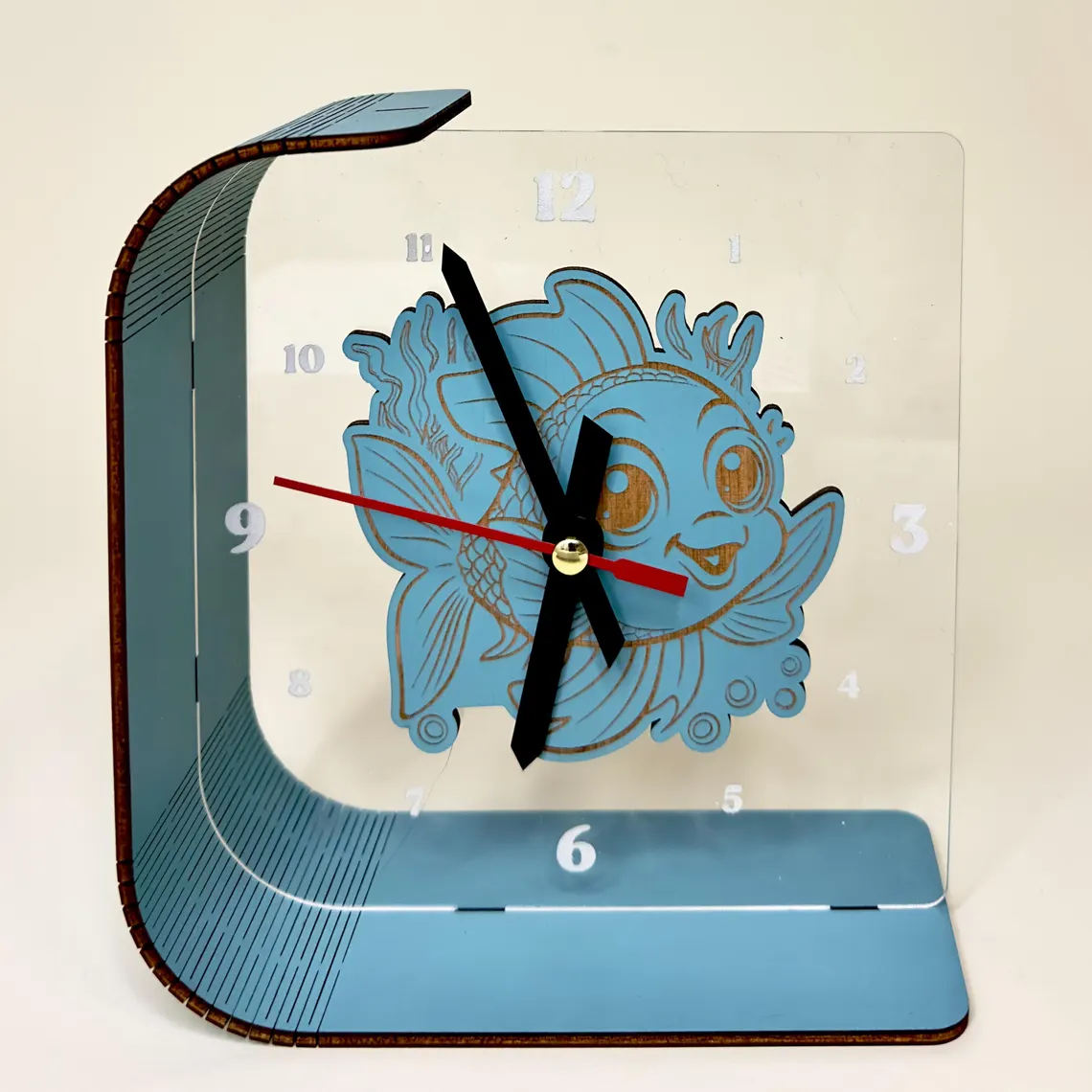 Blue decorative clock with a fish design on a beige background