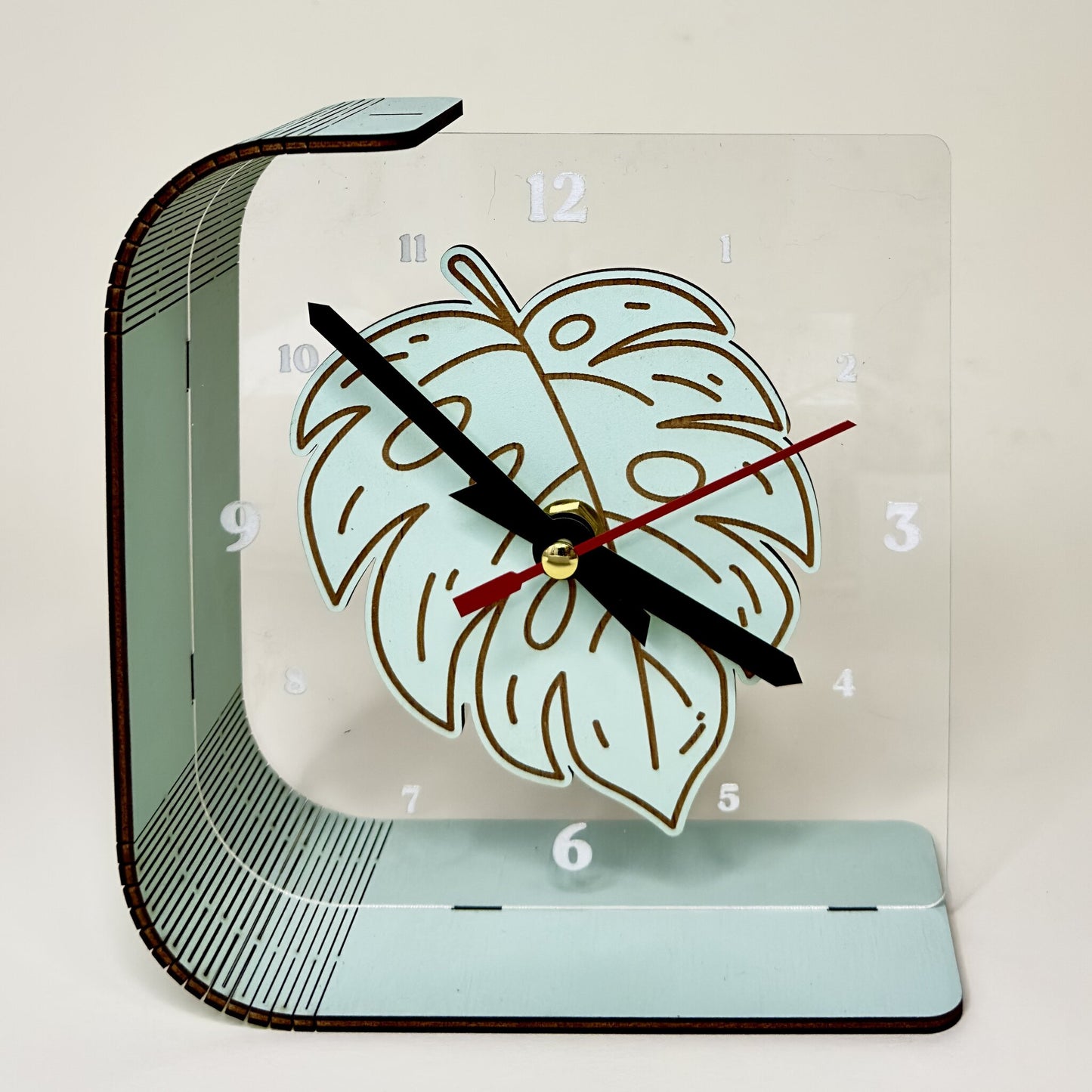 Desk clock with leaf design on a light background