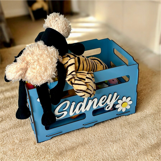 Blue toy crate with stuffed animals on a carpeted floor