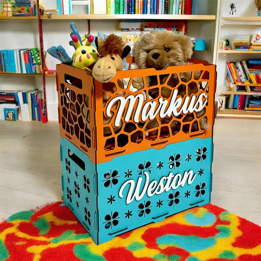 Orange and blue crate with stuffed animals inside, placed on a colorful rug in a room with bookshelves.